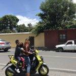 Mother rides motor scooter with children on back in Guatemala